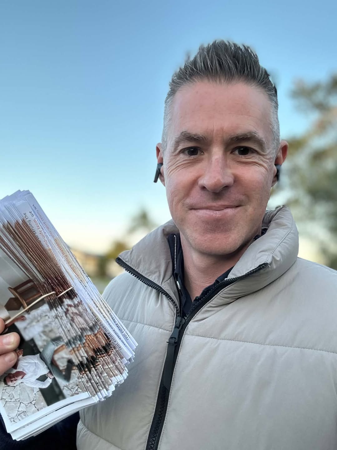 The founder holding a stack of Appraisal Magnet letterbox drops